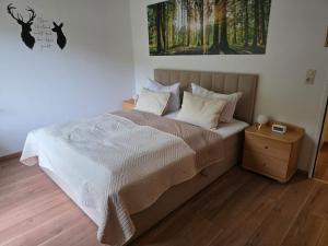 een slaapkamer met een bed en een schilderij aan de muur bij Ferienwohnung Carpe Diem in Bad Harzburg +20 foto's