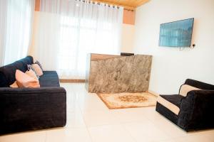 a living room with two couches and a flat screen tv at THELIGHT SUITES KIGALI Rwanda in Kigali