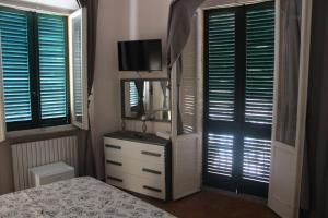 a bedroom with a bed and a dresser with a television at La Stazione #1 in Pontedera