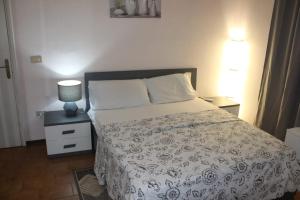 a bedroom with a bed and a lamp on a night stand at La Stazione #1 in Pontedera +8 photos