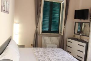 a bedroom with a bed and a window and a dresser at La Stazione #1 in Pontedera