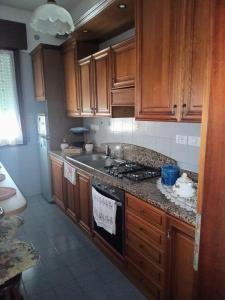 a kitchen with wooden cabinets and a stove top oven at Flat all for you in Treviso