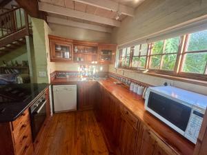 a kitchen with a wooden counter top with a microwave at Spurwing Cottage in Knysna +15 photos