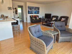 a living room with wicker chairs and a kitchen at Whaler's Cove in Portland