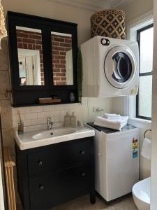 a bathroom with a sink and a washing machine at The Bungalow - Luxurious & Calm - Beach and Bush Retreat in Valla Beach