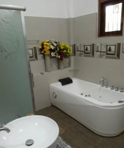 a bathroom with a tub and a toilet and a sink at The Garden Grove Villa in Yatiyana