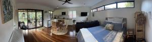 a bedroom with a bed and a living room at The Bungalow - Luxurious & Calm - Beach and Bush Retreat in Valla Beach