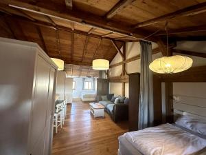 a bedroom with a bed and a living room with a couch at Moderne Landhaus Loft Nähe Mühldorf am Inn 