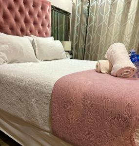 a bedroom with a large bed with a red headboard at Riverside 1 bedroom house for Two in Nelspruit +6 photos