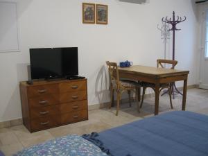 1 dormitorio con mesa y tocador con TV en Studio indépendant pour 1 - 2 personnes, en Château-la-Vallière