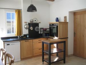 una cocina con una mesa y una estufa horno superior en Studio indépendant pour 1 - 2 personnes, en Château-la-Vallière