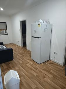 a room with a white refrigerator and a wooden floor at Room in Hostel in Rockhampton