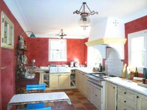 eine Küche mit roten Wänden und weißen Geräten in der Unterkunft Villa Laguna Haven in Saint-Tropez + 16 Fotos