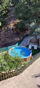 a swimming pool with two chairs and a fence at Anna's Country Villa Privé in Karés