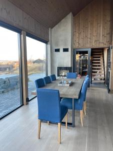a dining room with a wooden table and blue chairs at Spacious modern family chalet in Solhovda close to hiking, skiing & nature in Hol