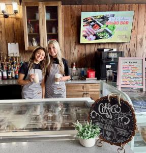 twee vrouwen staan achter een toonbank in een bakkerij bij Fiddler's Restaurant and Resort in Steinhatchee