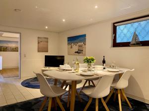 a dining room with a white table and chairs at Ferienwohnung Rantum in Heide