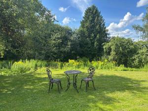 two chairs and a table in the grass at The 1st Apartment in Cēsis