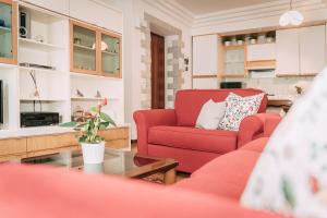 Una sala de estar con una silla roja y una mesa. en Palladio Apartment - Vista Fiume, In Centro con Garage, en Vicenza