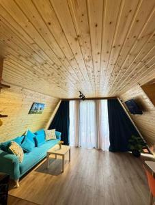 a living room with a blue couch and a wooden ceiling at Romantic Villa 2BR by the Sea in Tsikhisdziri +6 photos
