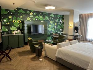 ein Zimmer mit einem Schlafzimmer mit Bett und Fernseher in der Unterkunft Hotel Sapin in Pom Prap