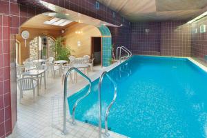 a swimming pool in a building with a table and chairs at Pansy Plot in Wooler