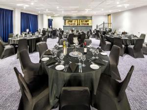 a conference room with tables and chairs with wine glasses at Mercure Cardiff North Hotel in Cardiff