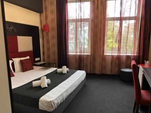 a hotel room with a bed with towels on it at Cattleya Boutique Hotel in Ruse