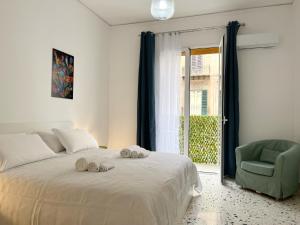 a bedroom with a bed and a chair and a window at Palermo central stay in Palermo