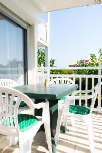 a green table and chairs on a balcony at Au Fil Des Vagues in Palavas-les-Flots