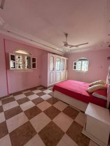 a bedroom with a red bed and a checkered floor at Luna Nile in Aswan +56 photos