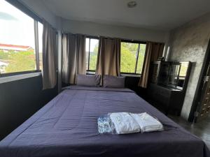Un dormitorio con una cama grande con sábanas y ventanas púrpuras. en BNK89 Hostel, en Bangkok 15 fotos más