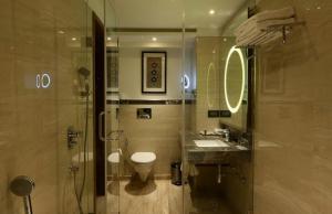 a bathroom with a toilet and a sink and a shower at Hotel Deluxe Stay Inn Delhi Airport in New Delhi