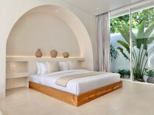 a bedroom with a bed and a large window at Dolce Suites in Bingin Beach