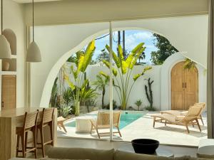 a living room with a table and chairs and a pool at Dolce Suites in Bingin Beach
