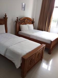 Dos camas una al lado de la otra en un dormitorio. en Hotel Nusantara, en Jertih 10 fotos más