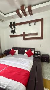 a bedroom with a large bed with red pillows at Comfort Deluxe Inn in Kigali