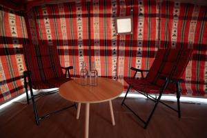 two chairs and a table in a room at Atana bidiyah private camp in Al Raka +25 photos