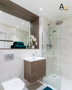a bathroom with a sink and a shower at Luxury Two-Bedroom Apartment - Free Wi-Fi, Close to Station, Ideal for Relocation Guests by AV Hughes Properties in Milton Keynes