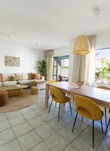 a living room with a large wooden table and chairs at Pura Vida by Maspalomas Holiday Villas in Pasito Blanco