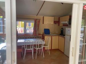 eine kleine Küche und ein Esszimmer mit einem Tisch und Stühlen in der Unterkunft Mobilhome 3 chambres in Mialet