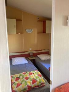 zwei Betten in einem kleinen Zimmer mit zwei Betten sidx sidx sidx in der Unterkunft Mobilhome 3 chambres in Mialet