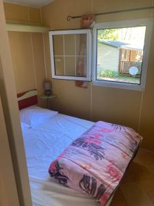 ein Schlafzimmer mit einem Bett und einem Fenster in der Unterkunft Mobilhome 3 chambres in Mialet