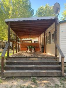 eine Holzterrasse mit einem Picknicktisch auf einem Haus in der Unterkunft Mobilhome 3 chambres in Mialet + 4 Fotos