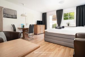 a bedroom with a bed and a table and a desk at Wiesenweg W07 in Laboe