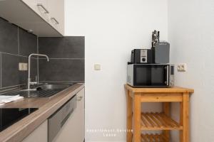 a kitchen with a sink and a microwave on a table at Wiesenweg W07 in Laboe