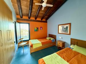 a bedroom with two beds and a ceiling fan at Casa Rural Madre del Agua. Finca El Robledillo in Monesterio +53 photos