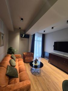 Una sala de estar con un sofá y un televisor de pantalla plana. en Green House Mindeli, en Tiflis