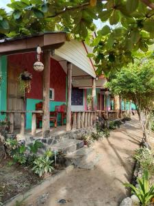 una casa con fachada roja y verde con porche en Relax Beach House, en Ko Lanta