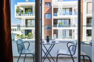 a table and two chairs in front of a window at Hilltop 2-Bedroom Apartment in Larnaca